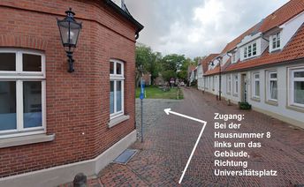 Bei der Hausnummer 8 links um das Gebäude, Richtung Universitätsplatz gehen