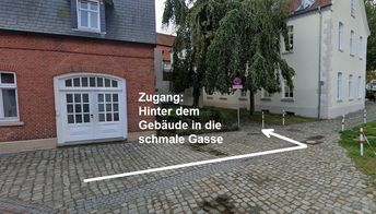 Hinter dem Gebäude in die schmale Gasse gehen.